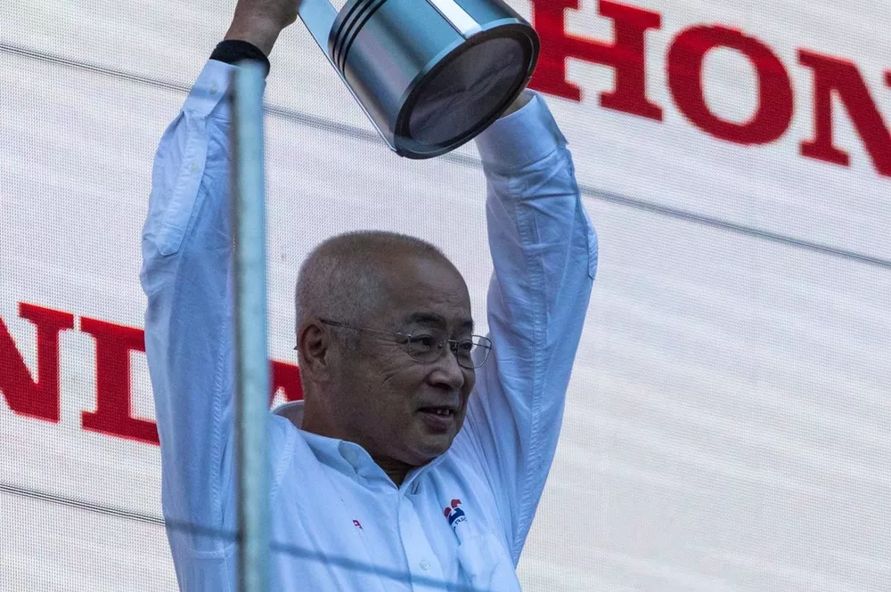 The Honda trophy delegate lifts the Constructors trophy on the podium