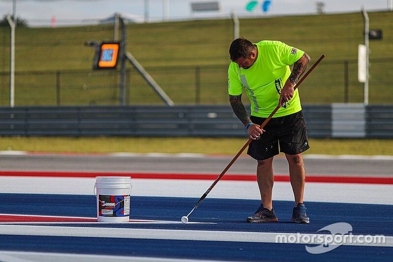 Workers paint the track