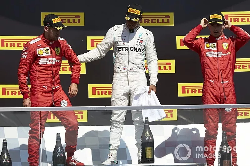 Sebastian Vettel, Ferrari, 2e plaats, Lewis Hamilton, Mercedes AMG F1, 1e plaats, en Charles Leclerc, Ferrari, 3e plaats, op het podium