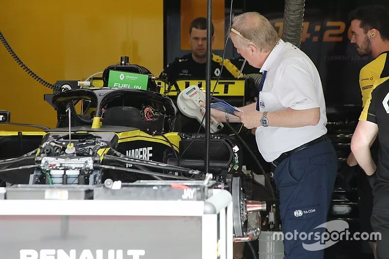 FIA delegatie Jo Bauer gebruikt een scanapparaat om meerdere chips te scannen die gebruikt kunnen worden om data te verzamelen over het chassis van Renault F1 Team.