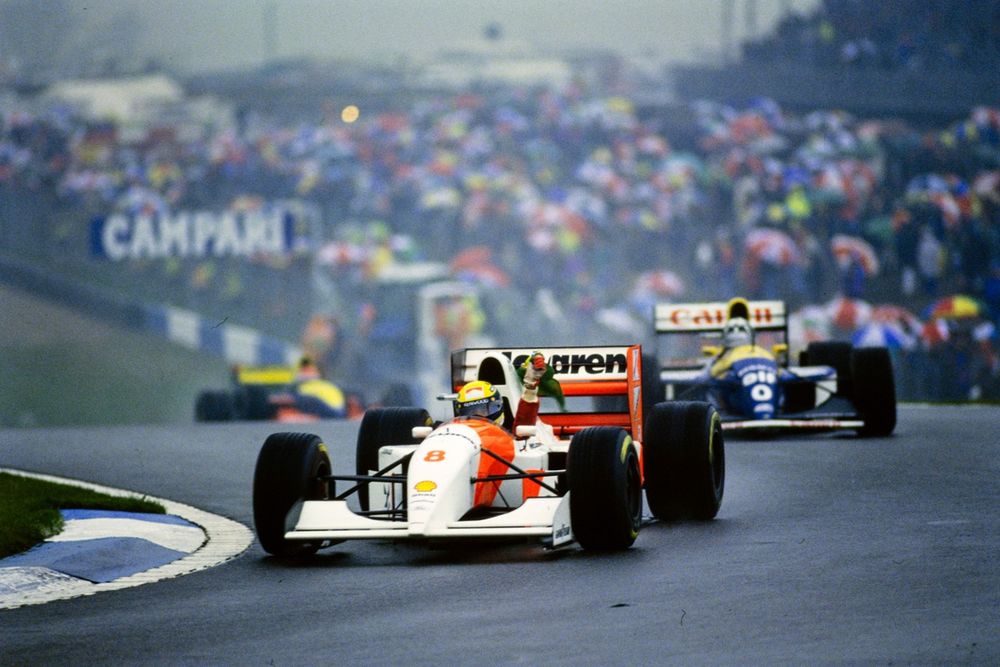 Ayrton Senna, McLaren MP4-8 Ford, waves a Brazilian flag in celebration in front of Damon Hill, Williams FW15C Renault.