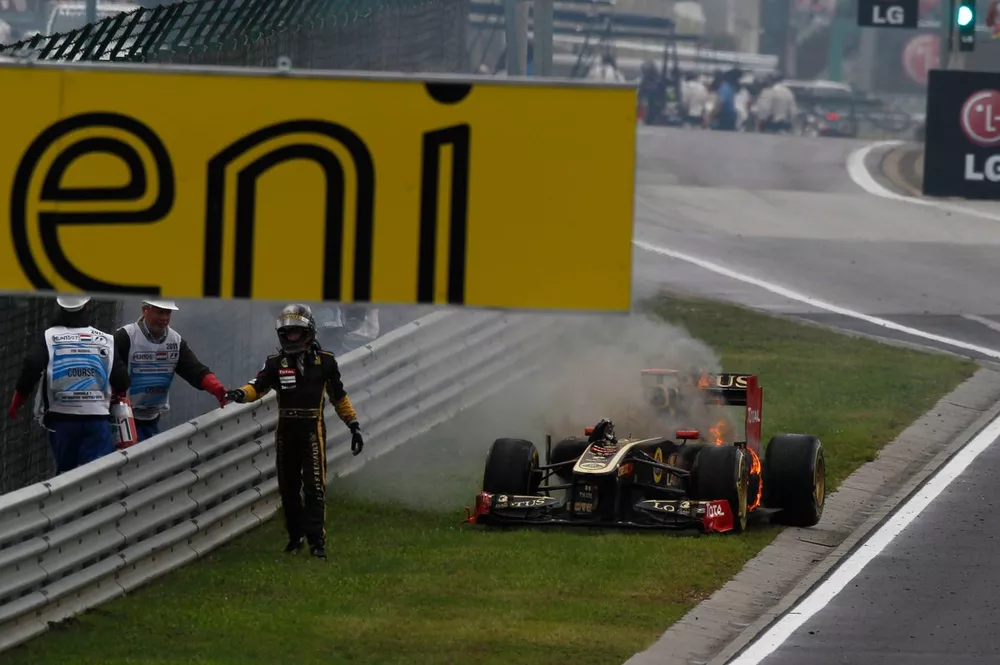 Nick Heidfeld, Lotus Renault GP R31, se aleja del coche en llamas tras salir de boxes.