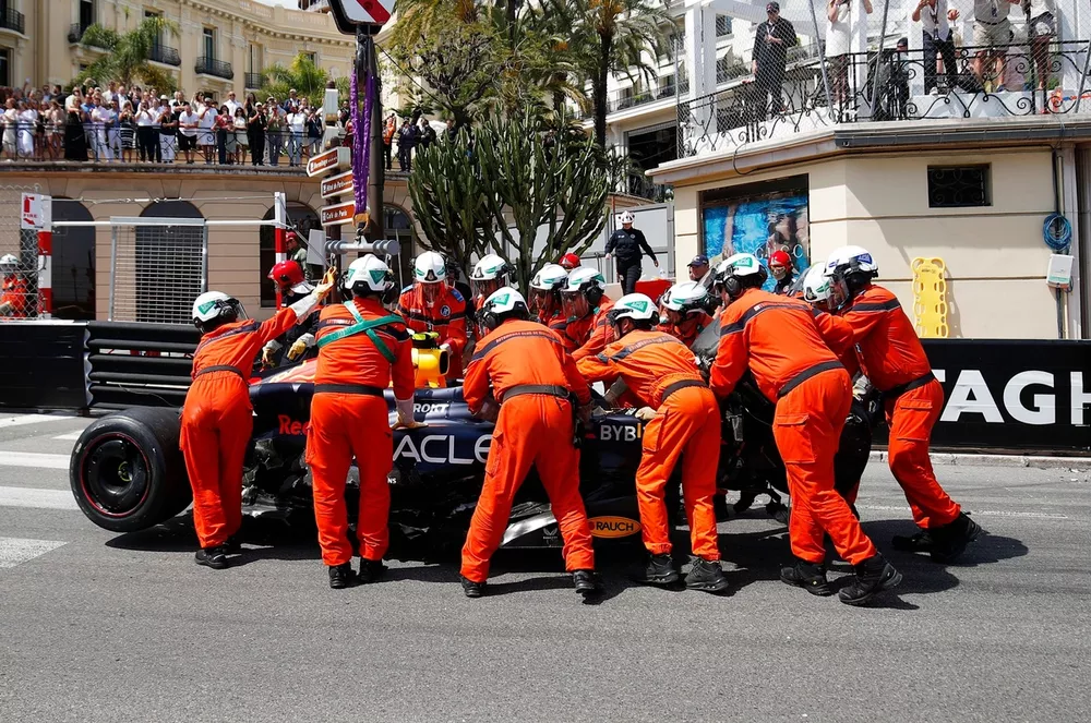 Marshals remove the damaged car of Sergio Perez, Red Bull Racing RB20, from the circuit after a crash on the opening lap