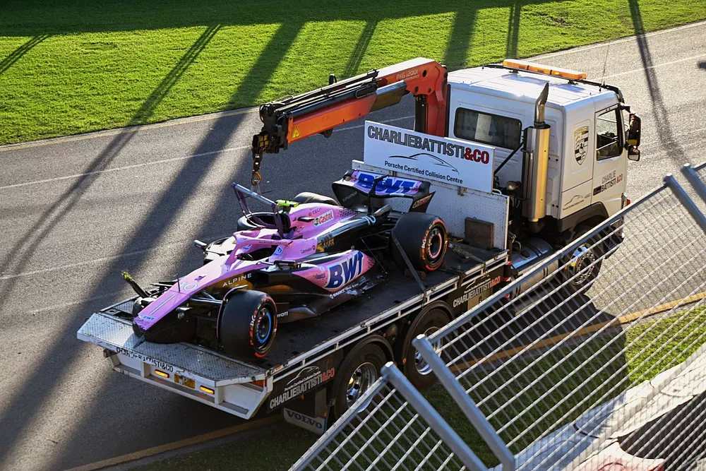Oficiales de pista retiran el coche da&ntilde;ado de Pierre Gasly, Alpine A523, con un cami&oacute;n tras la carrera