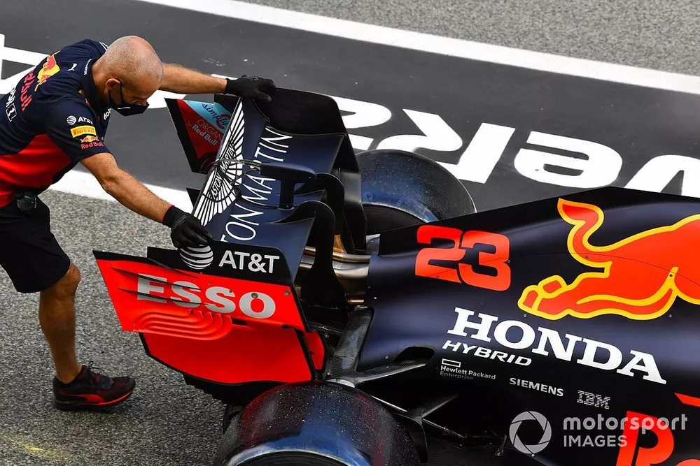Des m&eacute;caniciens poussent la Red Bull Racing RB16 de Alexander Albon dans la voie des stands