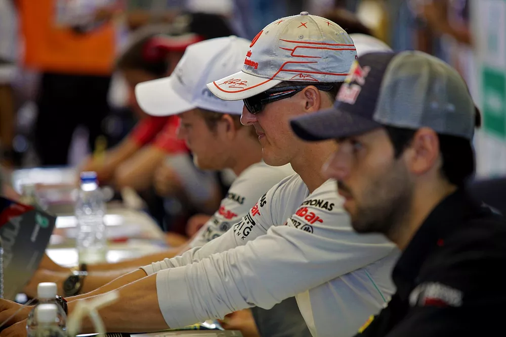 Nico Rosberg, Mercedes, Michael Schumacher, Mercedes y Jaime Alguersuari, Toro Rosso, firmando aut&oacute;grafos