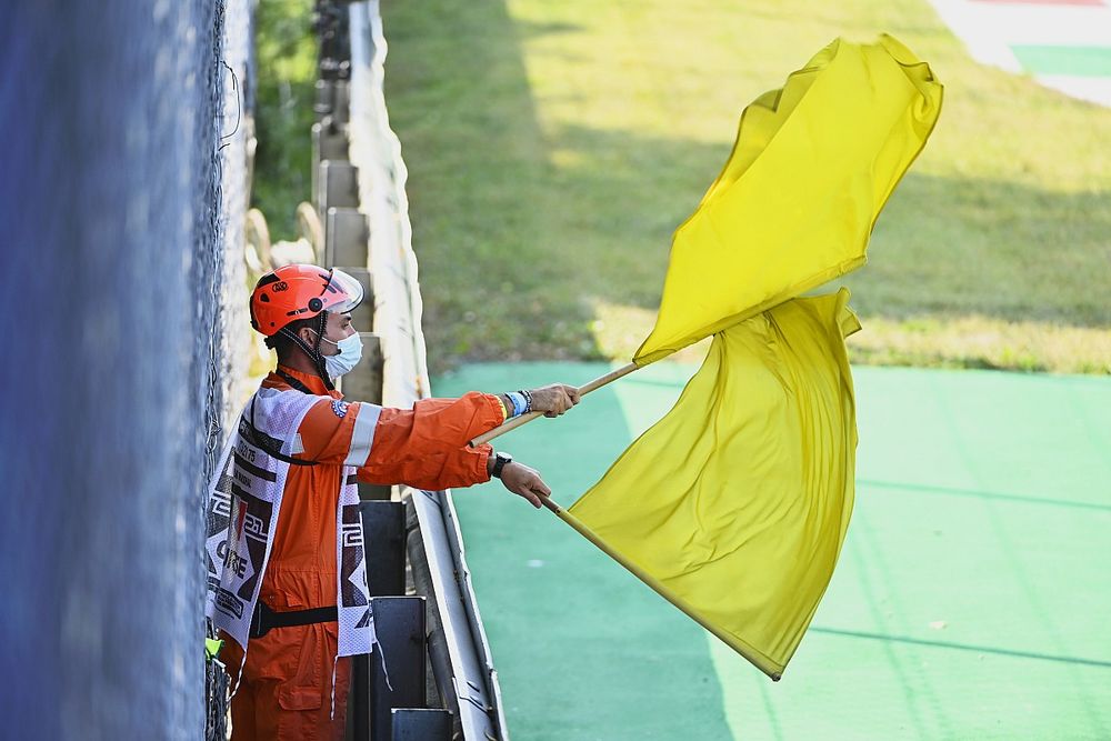 Sędzia macha podw&oacute;jnymi ż&oacute;łtymi flagami.