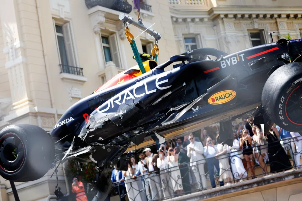 Marshals verwijderen de auto van Sergio Perez, Red Bull Racing RB20, van het circuit na een crash in de openingsronde