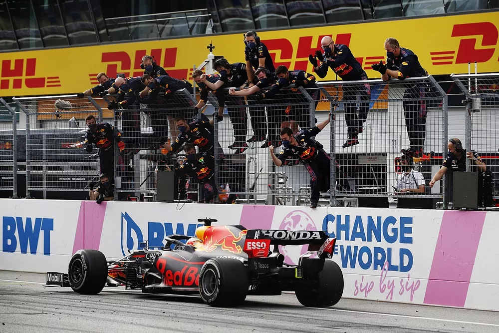 Max Verstappen, Red Bull Racing RB16B, 1st position, is cheered over the line by his team on the pit wall