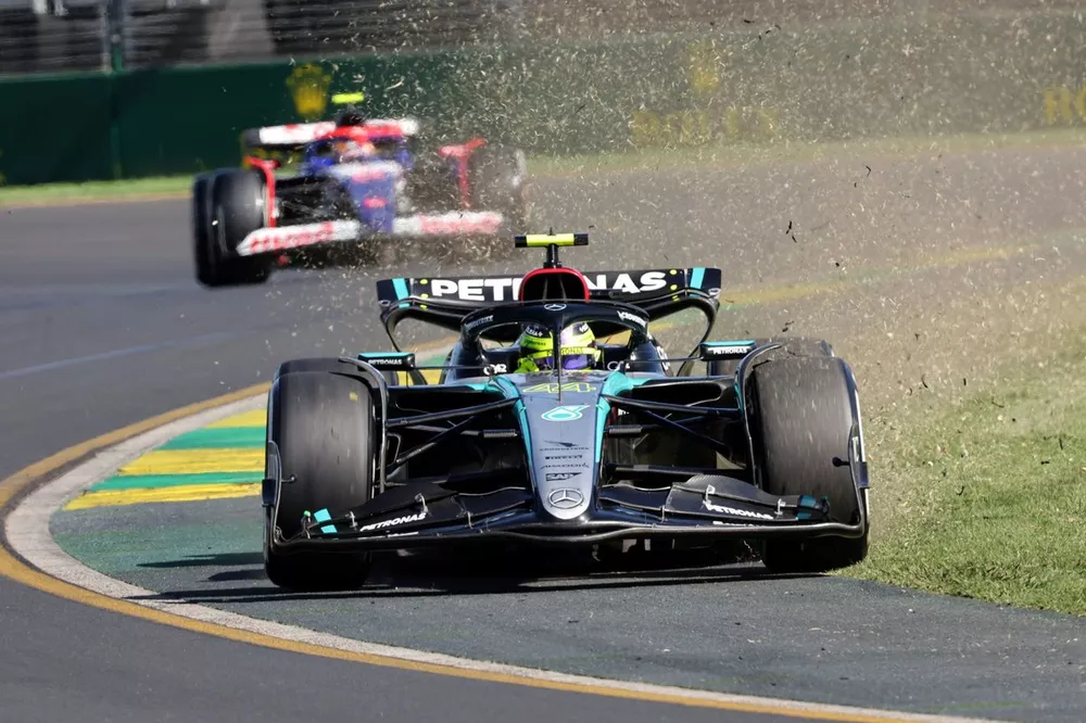 Lewis Hamilton, Mercedes F1 W15, kicks up grass and dirt ahead of Yuki Tsunoda, VCARB 01, after a brief cut