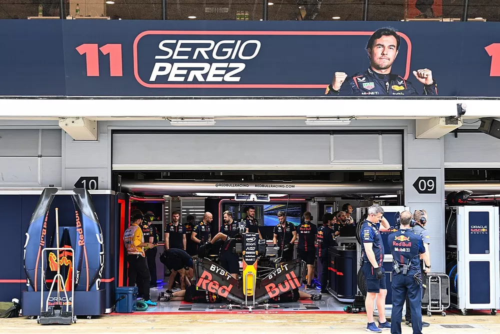 Mec&aacute;nicos en el garaje con el coche de Sergio P&eacute;rez, Red Bull Racing RB19