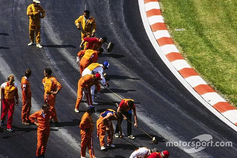 Marshals attend to the track as it keeps breaking up