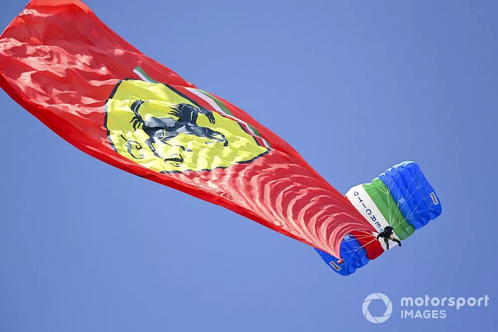 Una bandera de Ferrari es arrastrada por un paracaidista