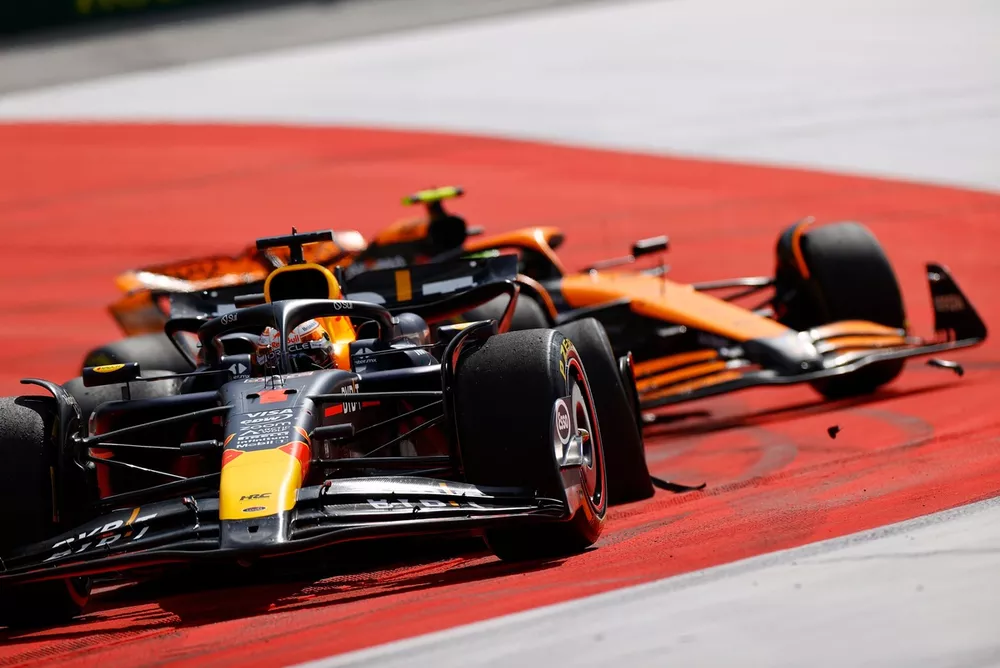 Max Verstappen, Red Bull Racing RB20, leidt Lando Norris, McLaren MCL38, nadat het tweetal contact heeft gemaakt. Verstappen rijdt met een beschadigd wiel en lekke band