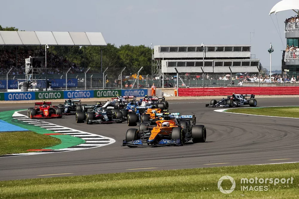 Lando Norris, McLaren MCL35M, Daniel Ricciardo, McLaren MCL35M, Sebastian Vettel, Aston Martin AMR21, and the remainder of the field at the restart