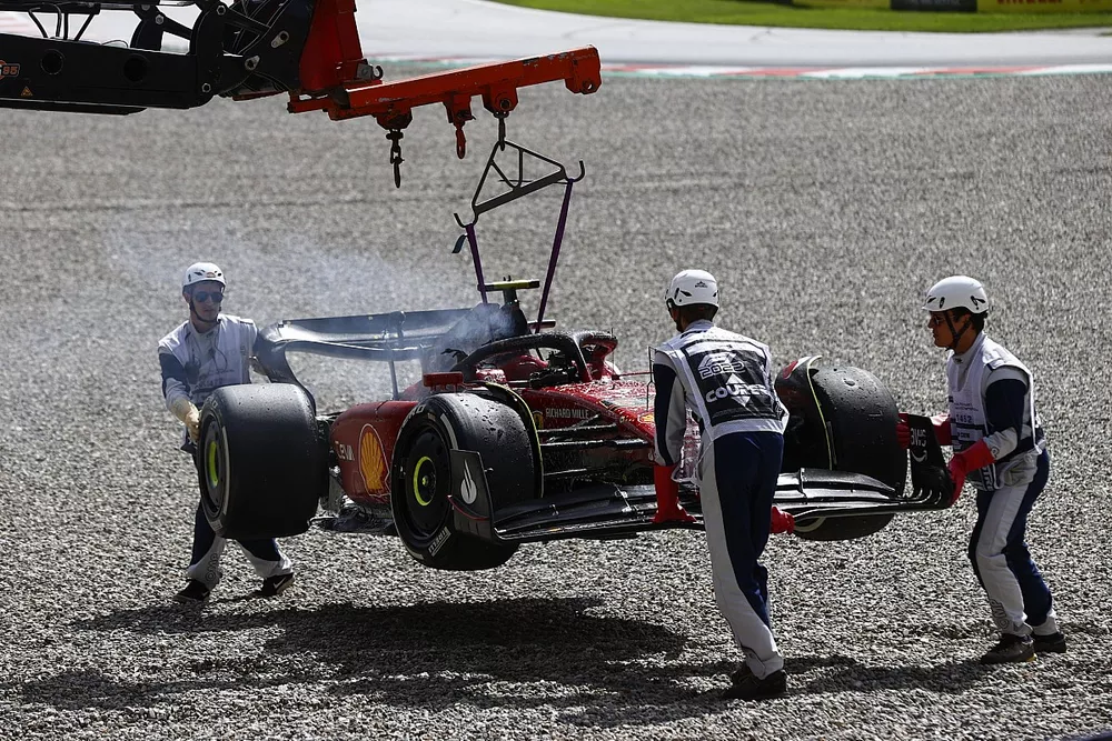 Marshals remove the fire damaged car of Carlos Sainz, Ferrari F1-75, from the circuit