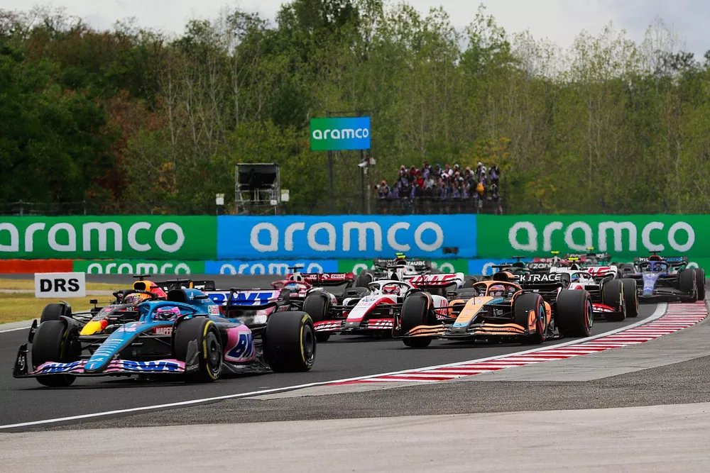 Fernando Alonso, Alpine A522, Max Verstappen, Red Bull Racing RB18, Daniel Ricciardo, McLaren MCL36, the remainder of the field on the opening lap