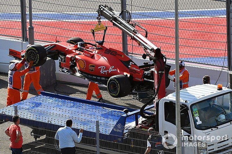 Los oficiales cargan el coche de Sebastian Vettel, Ferrari SF90, en una grúa