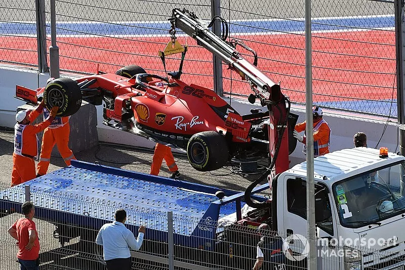 Los oficiales cargan el coche de Sebastian Vettel, Ferrari SF90, en una gr&uacute;a