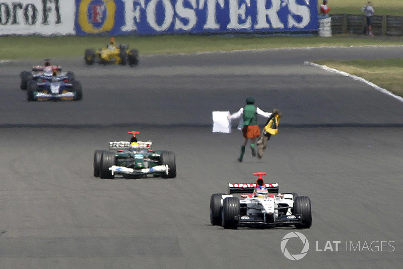 A man runs in front of the cars on track