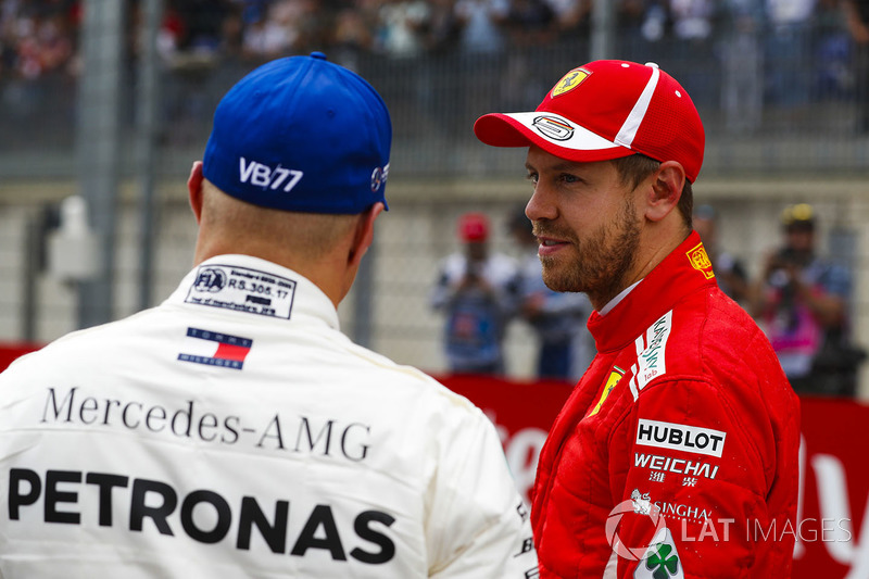 Third place Sebastian Vettel, Ferrari, talks to pole sitter Valtteri Bottas, Mercedes AMG F1, after qualifying
