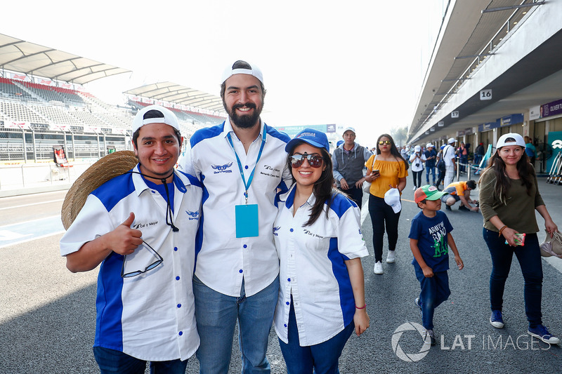 Fans pose for a photo in the pitlane,