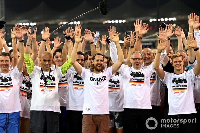 Sebastian Vettel, Aston Martin, es acompañado en una carrera alrededor del circuito por los miembros del equipo y parte de la gente de F1 como parte de su despedida en su último Gran Premio