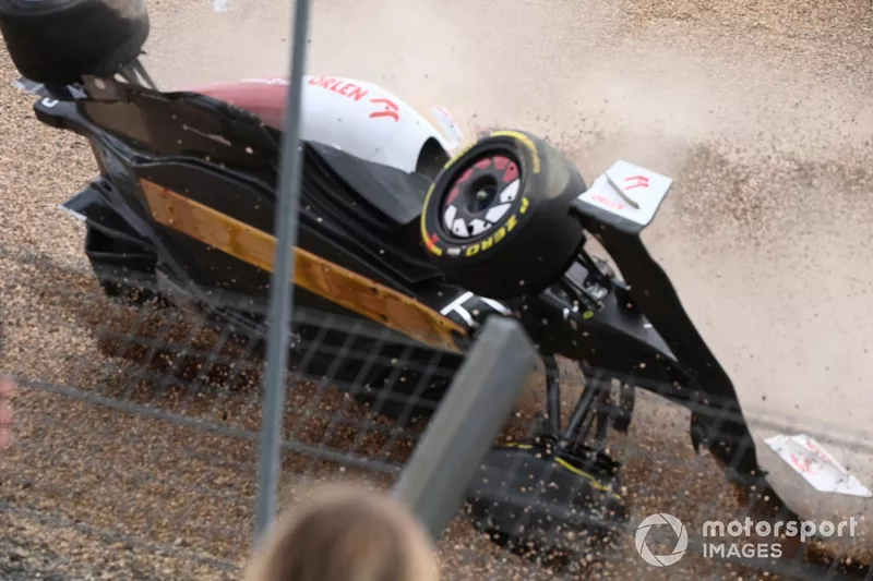 Zhou Guanyu, Alfa Romeo C42, slides across the gravel upside down after a crash at the start