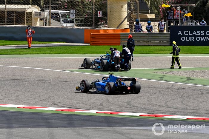Comisarios con el coche de Marcus Armstrong, Dams mientras pasa por ahí Felipe Drugovich, Uni-Virtuosi