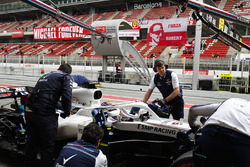 Robert Kubica, Williams, is attended to by mechanics in the pit lane