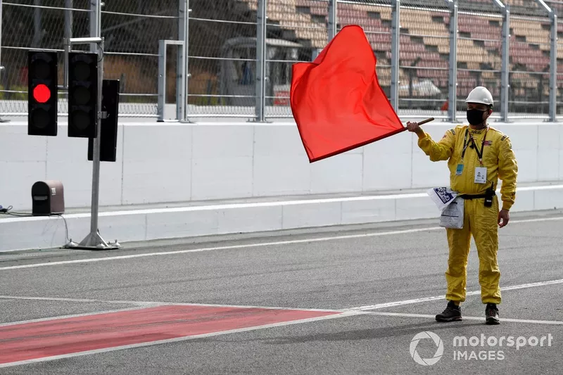 Un commissaire déploie le drapeau rouge