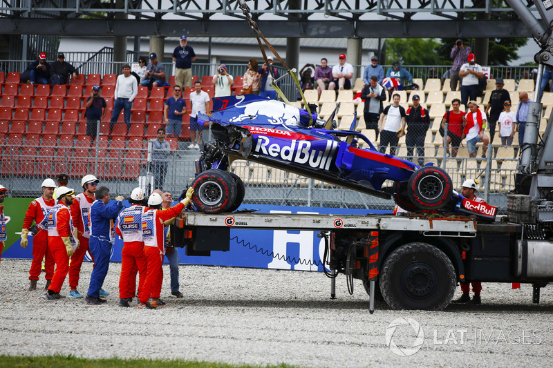 Porządkowi usuwają Toro Rosso STR13  Brendona Hartleya po poważnym wypadku