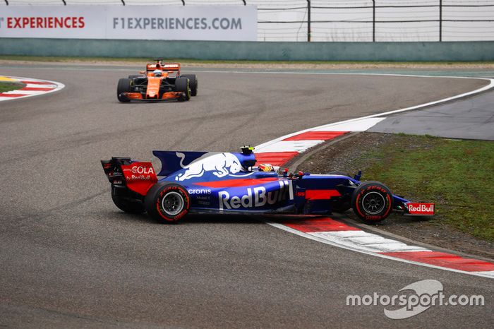 Carlos Sainz Jr., Scuderia Toro Rosso STR12, gira al inicio frente de Fernando Alonso, McLaren MCL32