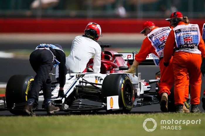 Kimi Raikkonen, Alfa Romeo Racing C38 se sienta en su coche mientras los oficiales empujan después de detenerse en la pista