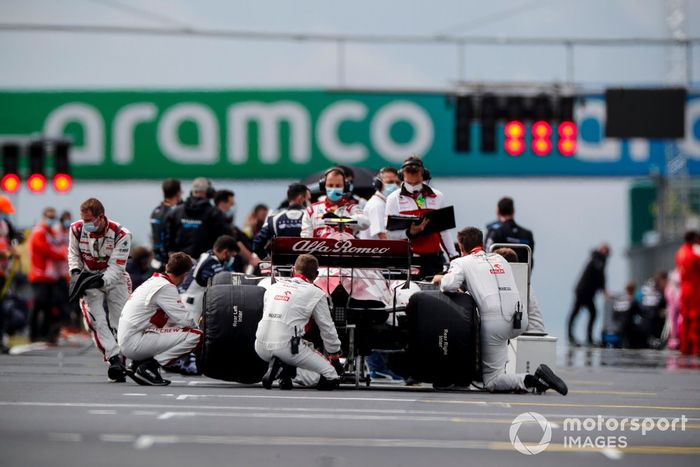 Los mecánicos atienden el coche de Antonio Giovinazzi, Alfa Romeo Racing C39, en la parrilla