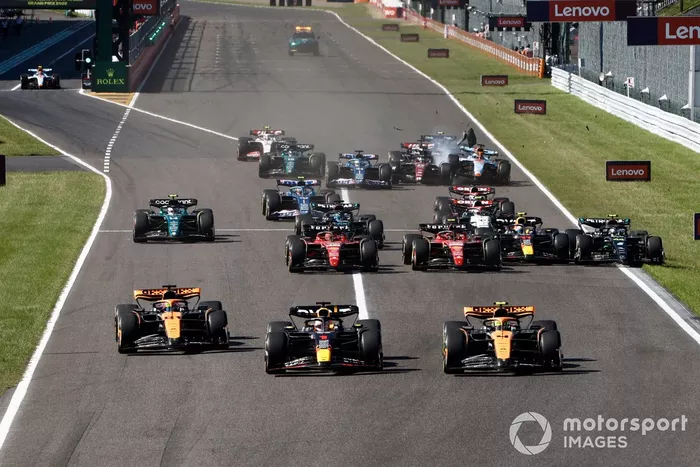Max Verstappen, Red Bull Racing RB19, Lando Norris, McLaren MCL60, Oscar Piastri, McLaren MCL60, el resto de la parrilla mientras se desarrollan los incidentes de contacto en el pelotón.