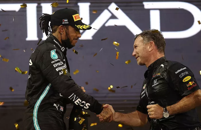 El director del equipo Red Bull Racing, Christian Horner, estrecha la mano del segundo clasificado, Lewis Hamilton, de Mercedes