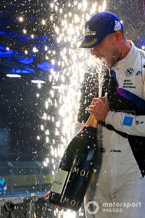 Racewinnaar Jake Dennis, BMW I Andretti Motorsport, eerste plaats, spuit Champagne in zijn mond op het podium