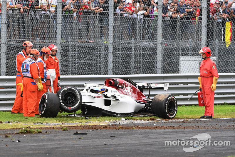 Les commissaires et la voiture accidentée de Marcus Ericsson, Alfa Romeo Sauber C37 après son crash en essais libres 2