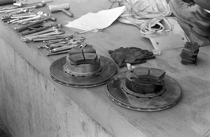 Discos de freno y pastillas de repuesto listas sobre el muro de pits