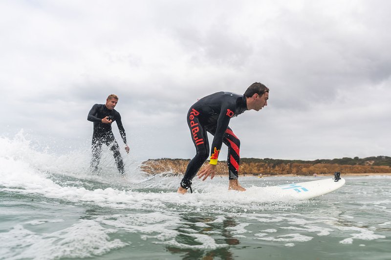 El tres veces campeón del mundo de surf Mick Fanning lleva a Pierre Gasly a surfear en Torquay