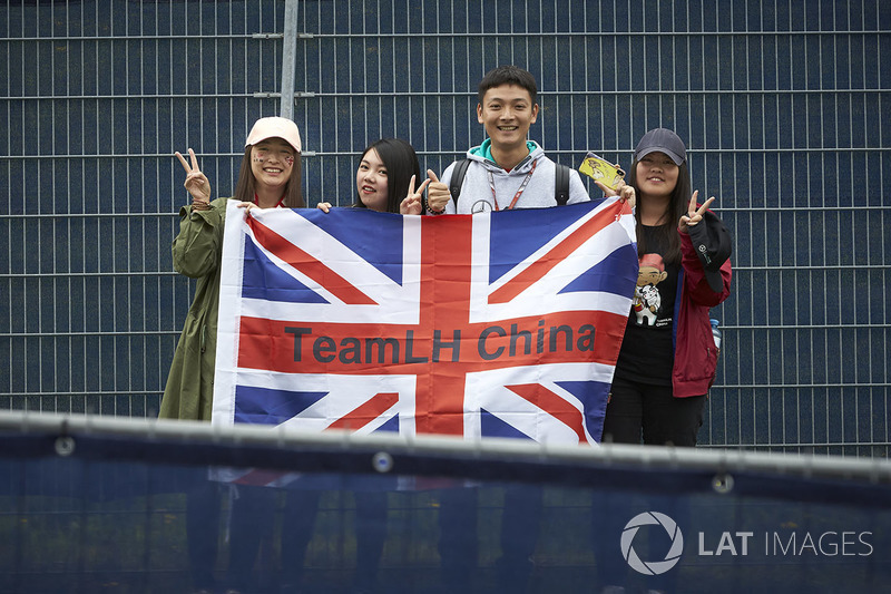 Fans of Lewis Hamilton, Mercedes AMG F1 W09, pose with a flag