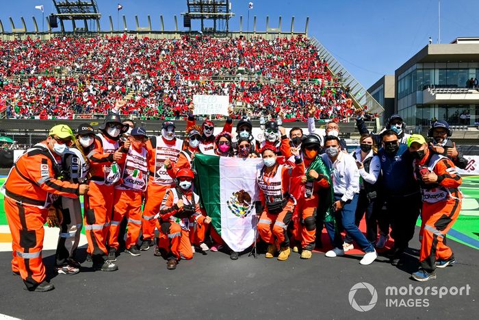 Oficiales de pista con la bandera de México