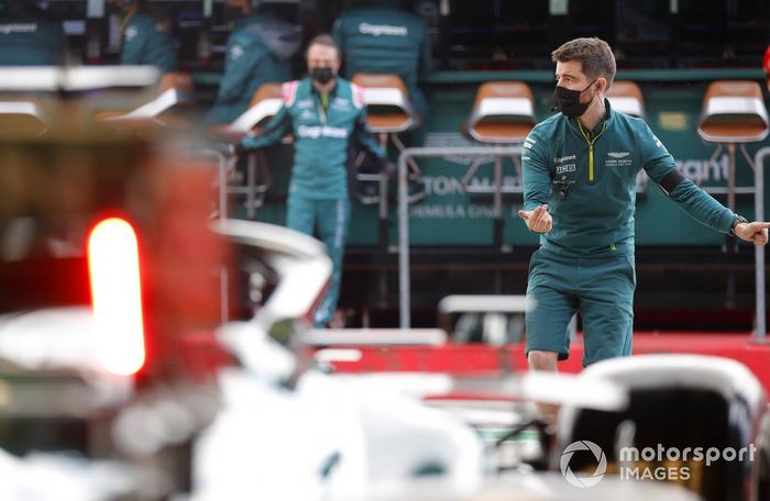 Un mecánico dirige a Lance Stroll, Aston Martin AMR21, fuera del garaje