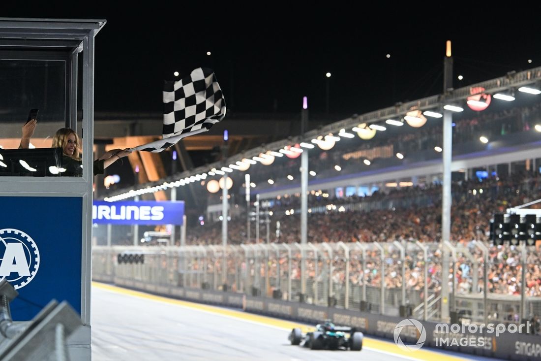 Kylie Minogue ondea la bandera a cuadros al final de la carrera al paso de George Russell, Mercedes F1 W15.