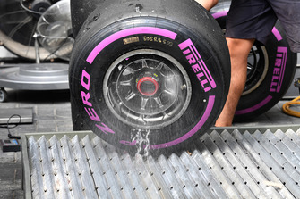 Red Bull Racing mechanics washes wheel rim and Pirelli tyre