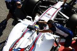 Felipe Massa, Williams FW40, is wheeled back into his garage by mechanics
