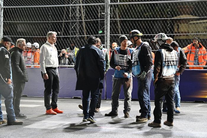 Los comisarios y el personal del circuito se reúnen para reparar una tapa de desagüe en la pista que provocó una bandera roja