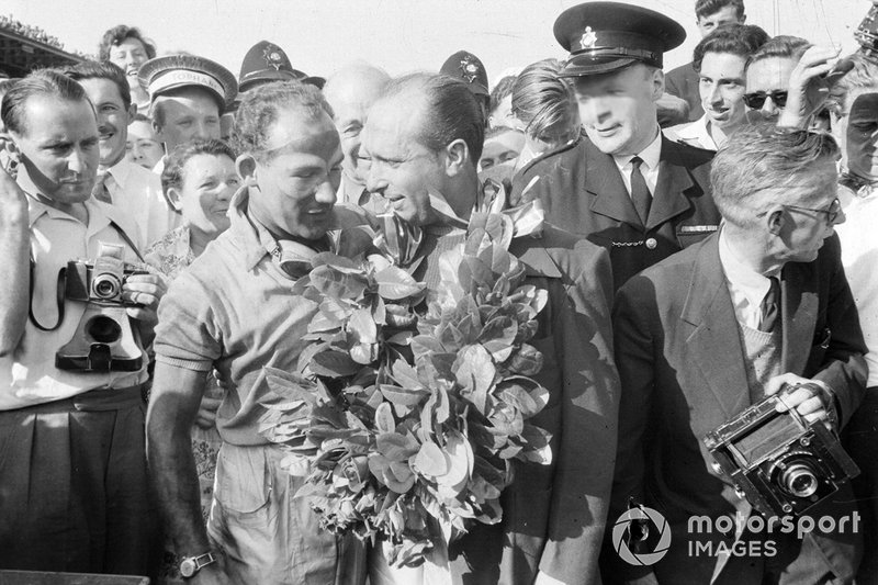Stirling Moss gives dà la sua ghirlanda del vincitore a Juan Manuel Fangio