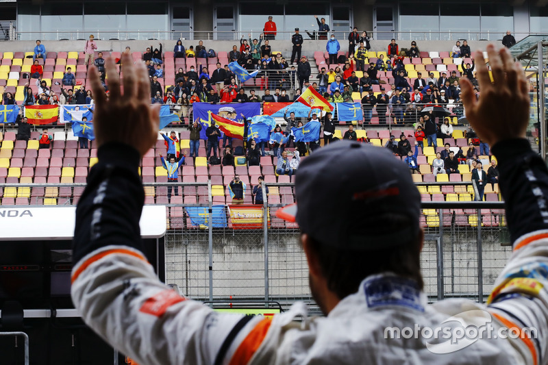 Fernando Alonso, McLaren, waves to fans in a grandstand